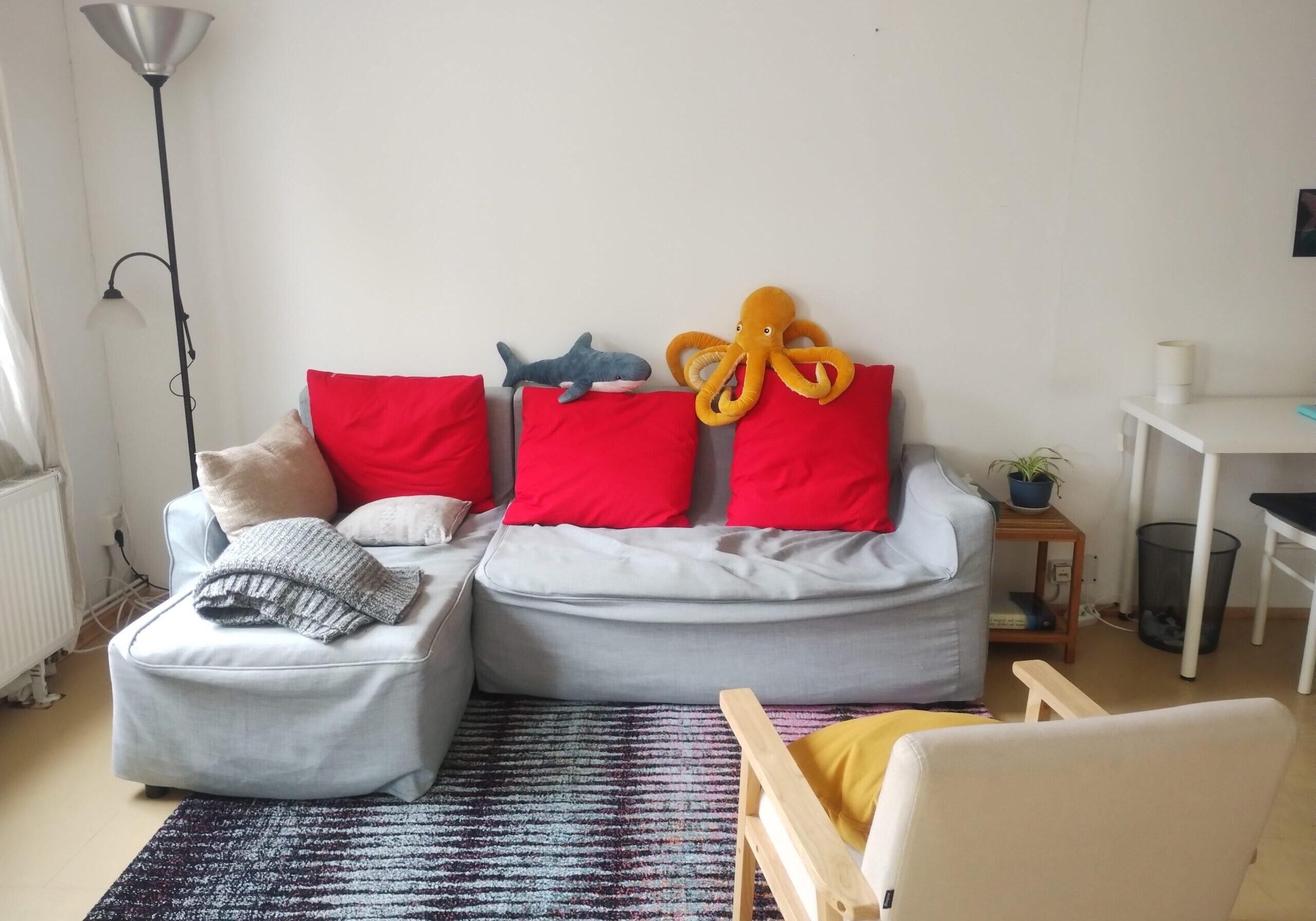 a couch with pillows and a stuffed animal on the back